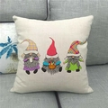 Detailed view of linen pillow cover with festive gnomes on a gray fabric sofa - Standard Square / Plaid Hats Gnomes Group with Basket (16)