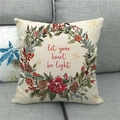 Detail view of linen Christmas pillow cover with floral wreath and holiday text on a sofa - Winter Berry Wreath Lettering (11)