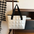 Silberne gesteppte Space-Cotton Puffer-Tragetasche mit schwarzen Griffen im Lifestyle-Look - Weiß