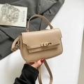 Elegant beige square handbag with top handle and gold twist lock shown in a lifestyle setting - Khaki