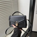 Minimalist black tote bag with gold oval twist lock and adjustable crossbody strap - Black