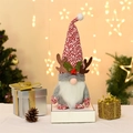 Weihnachtswichtel Plüschfigur mit Rentiergeweih und roter Strickmütze in Festtagsdekoration - Roter Hut Geweih Stil