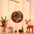 Detailansicht der Weihnachtsdekoration mit rot-schwarzem Karo, Rentier und Tannenzweig - Rotes Rentier