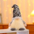 Detail of glowing Christmas gnome with silver sequin hat and warm LED light - Gray