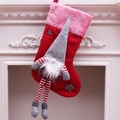 Large plush Christmas gnome stocking with legs and stars hanging on a white fireplace - Beard Style / Red