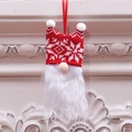 Gnomo di Natale con cappello rosso a maglia e barba bianca appeso a un caminetto - Stile Fiocco di Neve