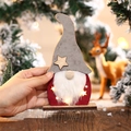 Detalle de gnomo navideño LED con base de madera y luz en forma de estrella - Gnomo de sombrero gris
