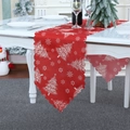 Close-up of red Christmas table runner with white snowflake prints and scalloped edges - Christmas Tree