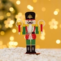 Bunte Nussknacker-Soldat-Figur aus Holz mit Glitzerdetails auf Schnee-Hintergrund - Soldat Mit Kerzen