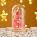 Detail eines rosa Mini-Weihnachtsbaums mit warmen LED-Lichtern in einer Glaskuppel - Rosa Baum-Stil