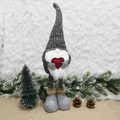 Detalle de gnomo navideño con piernas largas, corazón rojo y decorado festivo - Gris