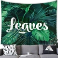 Detail of tropical monstera leaf tapestry with Leaves text above a grey sofa - Broadleaf Style (7) / 100X70