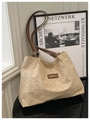 Dettaglio della borsa shopper beige trapuntata con manici marroni, tessuto testurizzato e stile. - senza ciondolo / Bianco