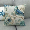 Linnen kussensloop met blauwe vogel en bloemenprint op een grijze bank - Blauwe Vogel en Bloem Kunststijl (3)