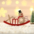 Detail of wooden Xmas sign with red rocking base and snowman ornament for Christmas decor - Snowman