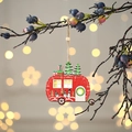 Leuchtender roter Holz-Camper mit Miniaturbaum und Schneemann am Ast aufgehängt - Auto
