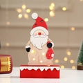 Close-up of lighted wooden Santa Claus figurine with star cutouts and warm glowing light - Small Santa Claus Balloon