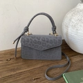 Gray leopard print suede handbag with top handle and gold hardware on wood surface - Grey Leopard