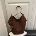 Deep brown suede bucket tote bag with wide opening and slim handles in room setting - Brown