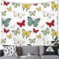 Detalle de tapiz con mariposas en acuarela colgado sobre un sofá gris de salón - Estilo 1 / 150x100(Piel de Melocotón)
