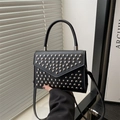 Black leather crossbody bag with silver rivet studs and a top handle in modern urban style - Black