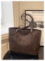 Detail of vintage dark brown tote bag showing the Creative Cat embossed leather patch - Brown