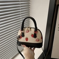 Schicke cremefarbene Muschel-Handtasche mit Erdbeerdruck und schwarzen Kontrastgriffen - Schwarz