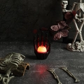 Macro view of Halloween skeleton hand holding a red glowing eyeball lamp with bloodshot detail - Black Eye Skeleton Hand Light