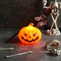 Nahaufnahme einer beleuchteten Kürbislampe mit Skelett für Halloween Party Deko - Orange Tragbare Kürbis Laterne