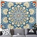 Detail view of a bohemian blue mandala tapestry on a white wall above a grey sofa - Mandala Style 9 (9)