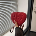 Compact red heart-shaped coin purse with quilted leather texture and a handy wrist strap - Red