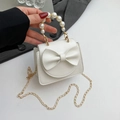 Mini borsa bianca con fiocco, manico di perle e catena dorata su tessuto grigio scuro - Bianco