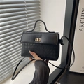 Chic black Kelly bag with houndstooth texture and gold rotary buckle for elegant hand-carry - Black