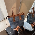 Bolso vintage de mezclilla azul con ribete de cuero marrón y remaches dorados en estudio - Azul