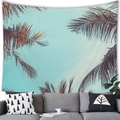 Tropical coconut tree tapestry hanging over a gray sofa in a modern living room - 100x70cm / Palm Leaves Blue Sky Nordic-Peach Skin