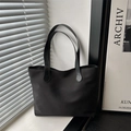 Borsa tote minimalista in nylon nero con cuciture a goccia su un davanzale moderno - Nero