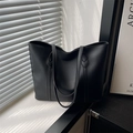 Borsa tote minimalista in ecopelle nera con manici lunghi mostrata in luce naturale - Nero