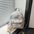 Mini-Rucksack in Grau mit Schmetterlingsdruck und Plüsch-Anhänger im Tageslicht - Mit Anhänger / Grau