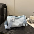 Light blue cylinder pillow crossbody bag with white embroidery and wide shoulder strap - Blue