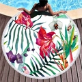 Round floral beach towel with green leaves and white fringe on a wooden pool deck - Red Purple Floral Style