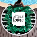 Round beach towel with green tropical leaves and tassels on poolside wood deck - Black and White Striped Tropical Leaves Style