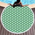 Round beach towel with white tassels featuring green tropical leaf patterns on poolside - Monstera Leaf Style