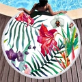 Circular beach towel with vibrant tropical floral pattern and white tassels on pool deck - Red Purple Floral And Palm Leaves (1)