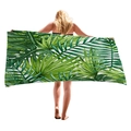 Tropical monstera leaf print beach towel held by model showing large rectangular size - 150x75cm / Fresh Tropical Green Leaves Style (5)