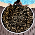 Thick black and gold mandala round beach towel with white tassels on a poolside deck - Exotic Elegant Design (5)