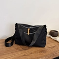 Minimalist black nylon crossbody bag with multi-layer zippers and orange accent strap - Black