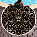 Round black and gold mandala beach towel with white tassels displayed by a pool deck - Classic Black Gold Mandala (10)