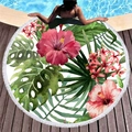 Rundes Strandtuch mit roten Blumen, grünen Blättern und weißen Quasten auf Holzdeck - Weißer Hintergrund Rotes Hibiskusmuster / Roter Hibiskus Grüne Blätter