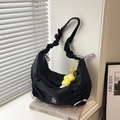 Borsa a tracolla in nylon nero con spalline a pieghe e ciondolo a fiore giallo su libri - Con ciondolo / Nero