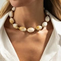 Short beaded necklace featuring large amber-patterned marble beads and gold accents - White